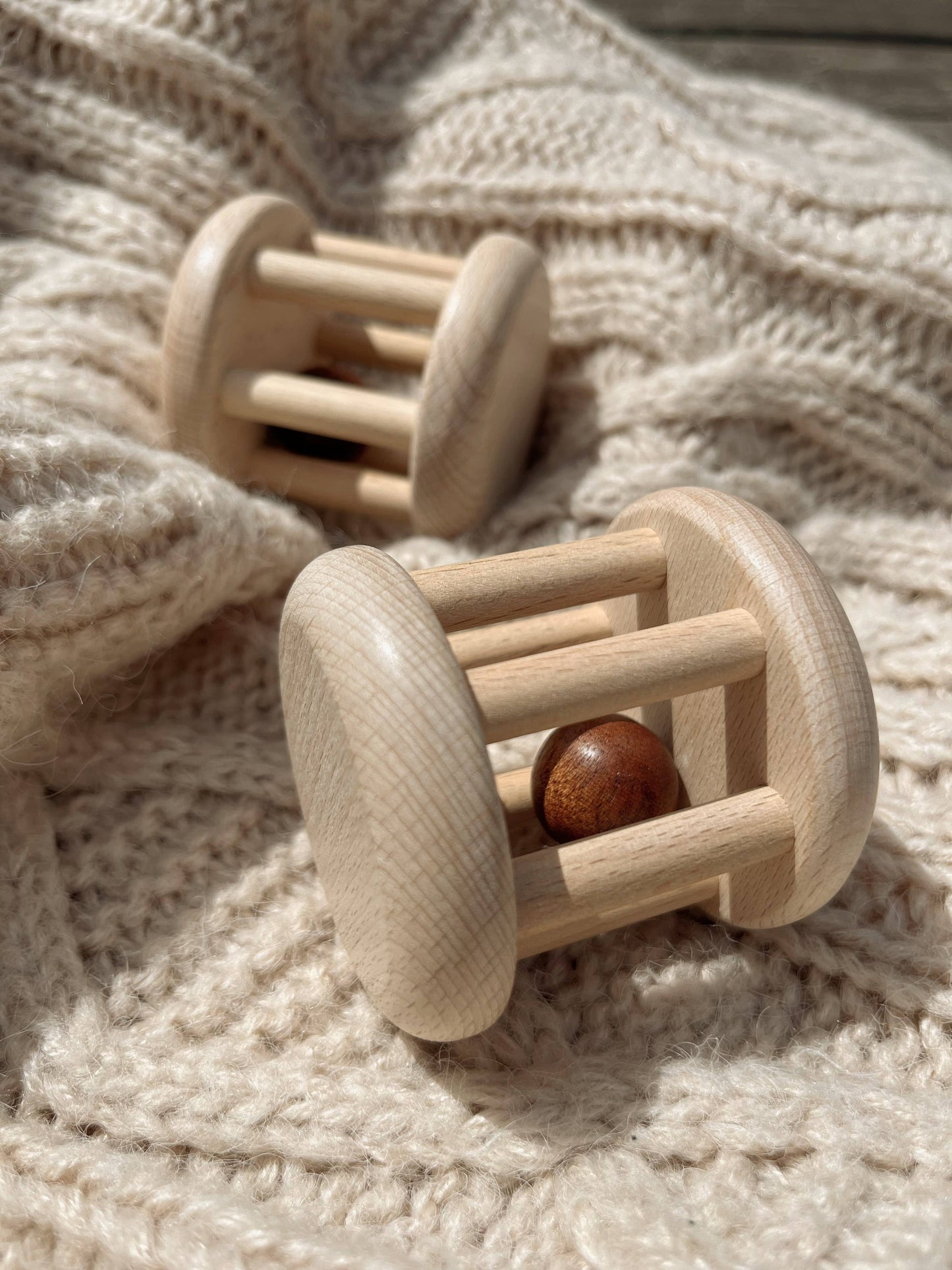 Wooden baby rattle on a soft fabric background