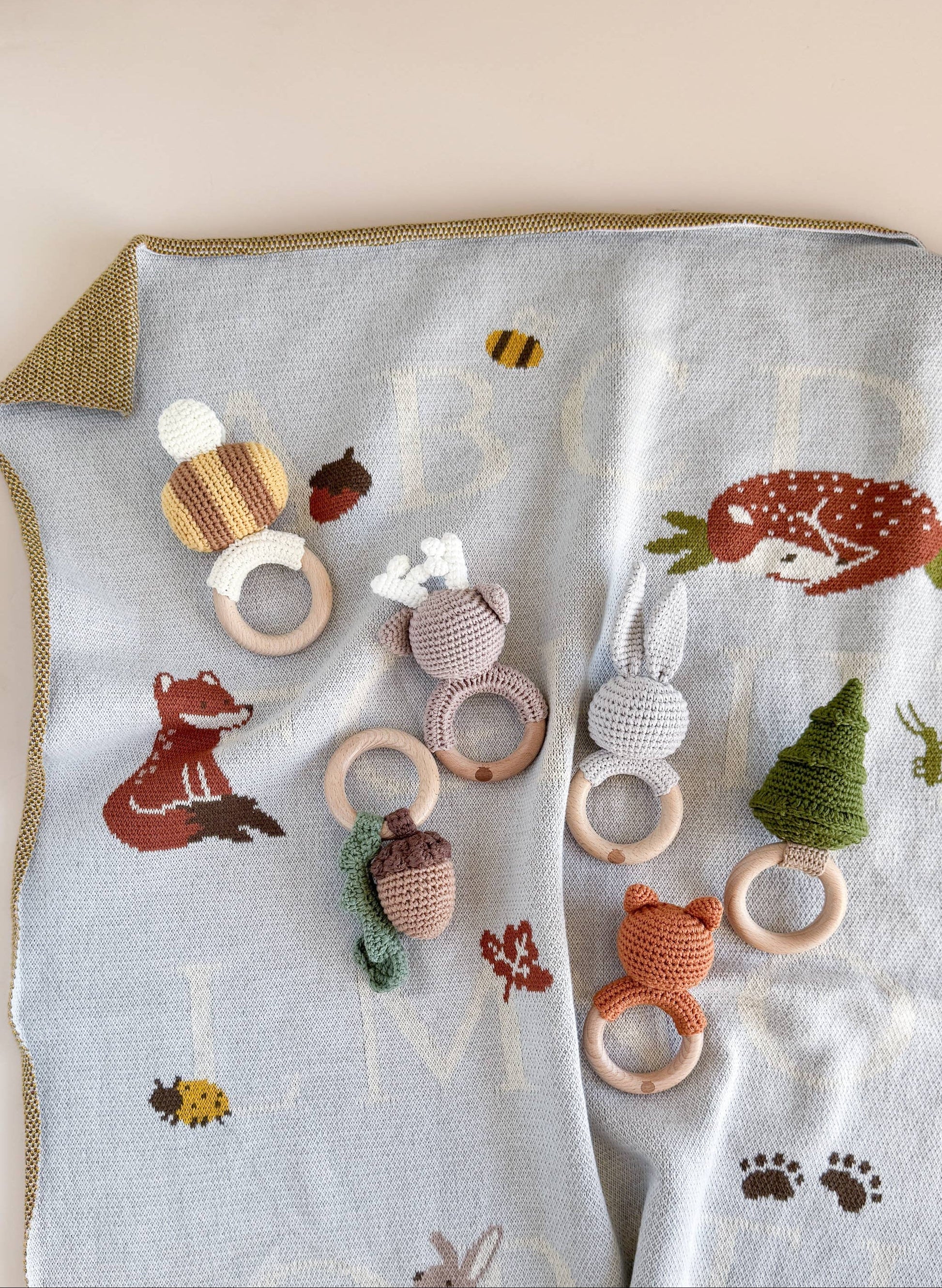 Set of wooden baby teething rings with crochet  animal designs on a blanket