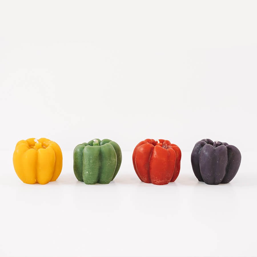 Four colorful wax candles in different shapes on a white background