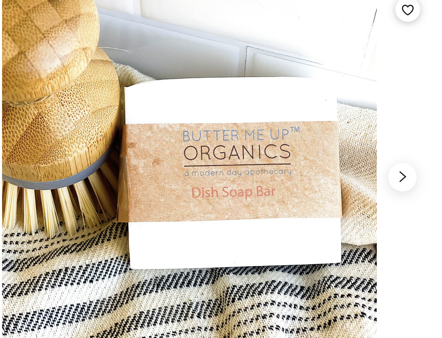 Butter Me Up Organics dish soap bar with a brush on a textured surface