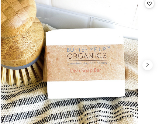 Butter Me Up Organics dish soap bar with a brush on a textured surface