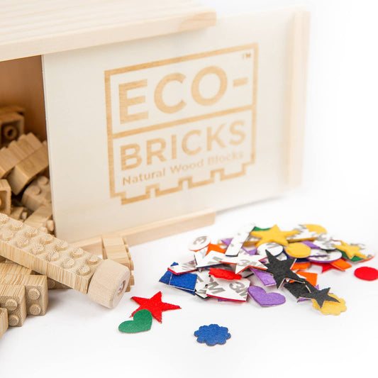 Wooden eco-bricks with colorful felt pieces on a white background