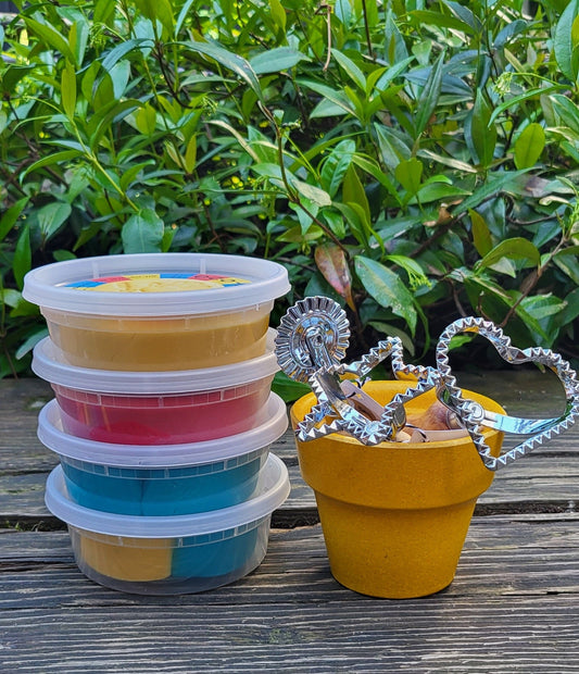 all colors of play dough with three cutters in a pot
