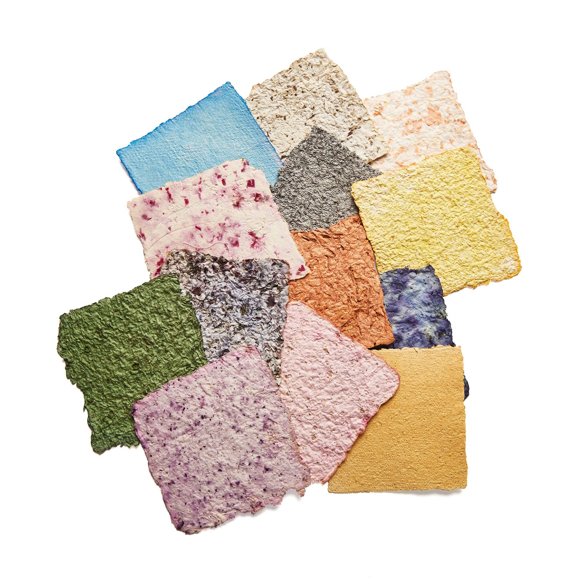 Collection of colorful paper squares from a paper-making kit on a white background