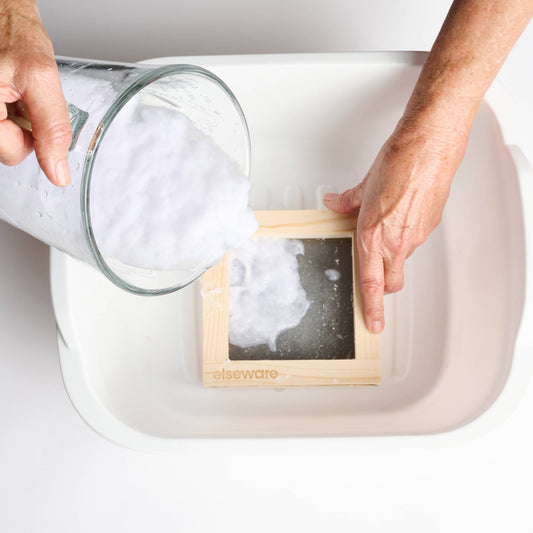 Person making handmade paper in a tub