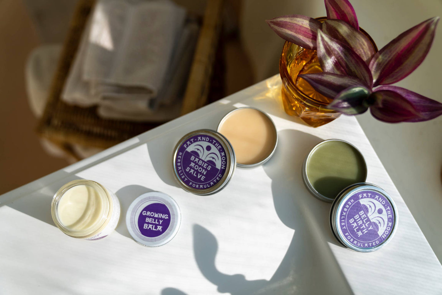 three different salves by Fat and the Moon on a white shelf