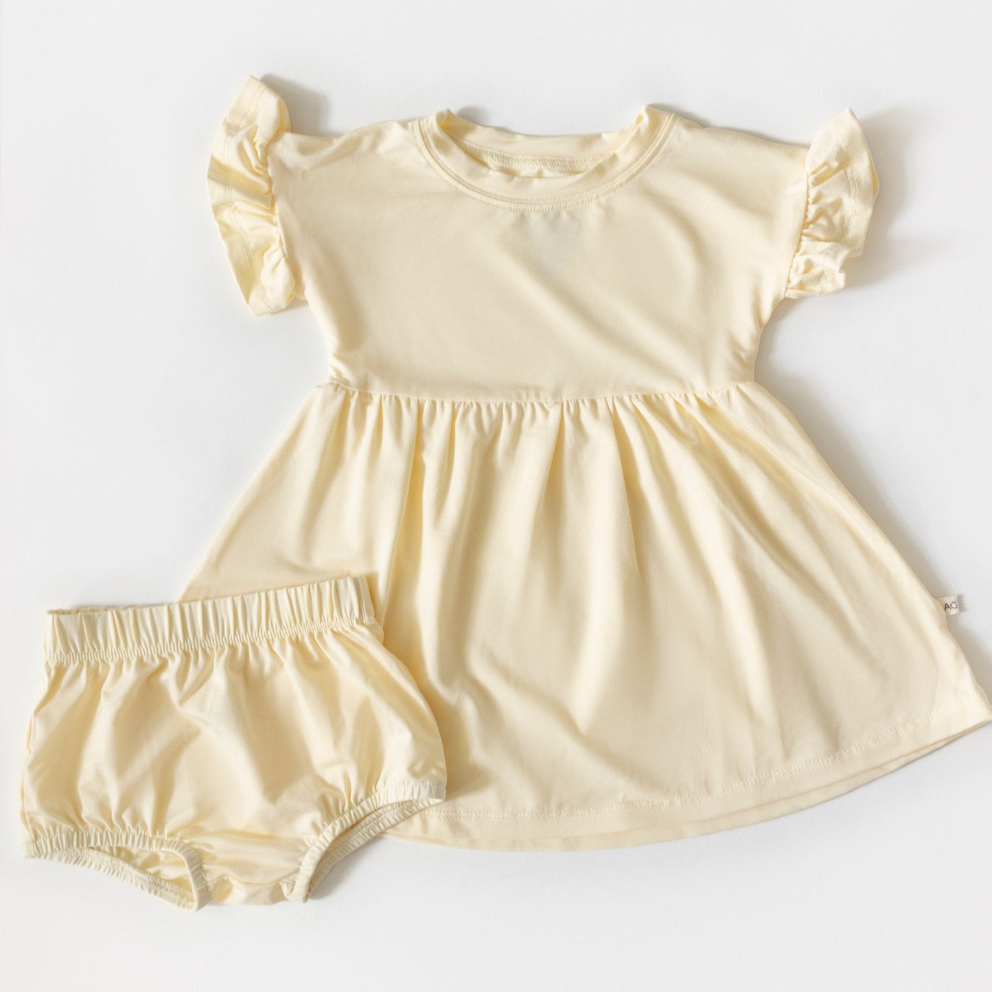 Yellow baby dress with matching bloomers on a white background