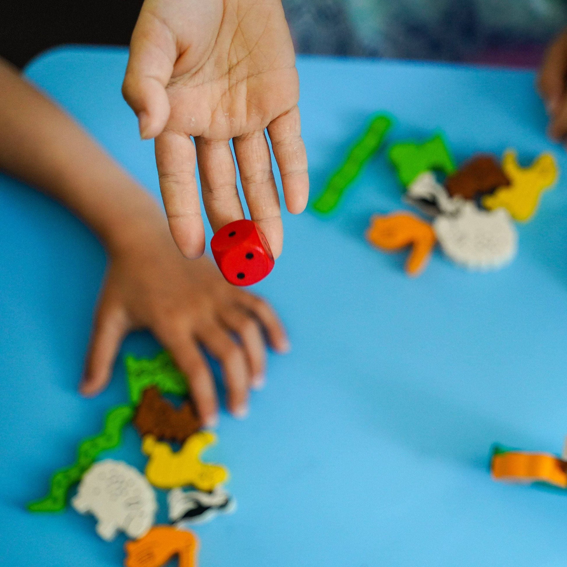 kids playing Animal Upon Animal Stacking Game and the red dice rolling
