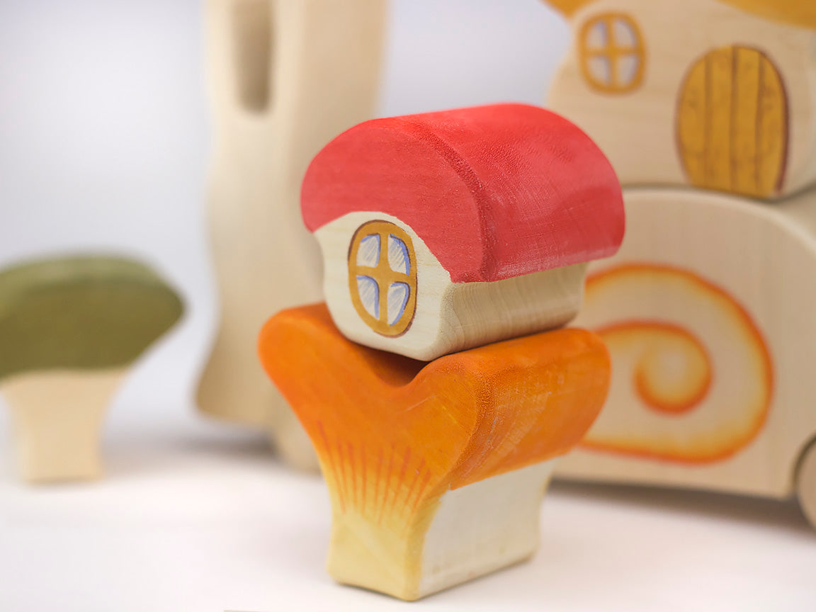 Wooden toy with a red roof and yellow windows on a white background