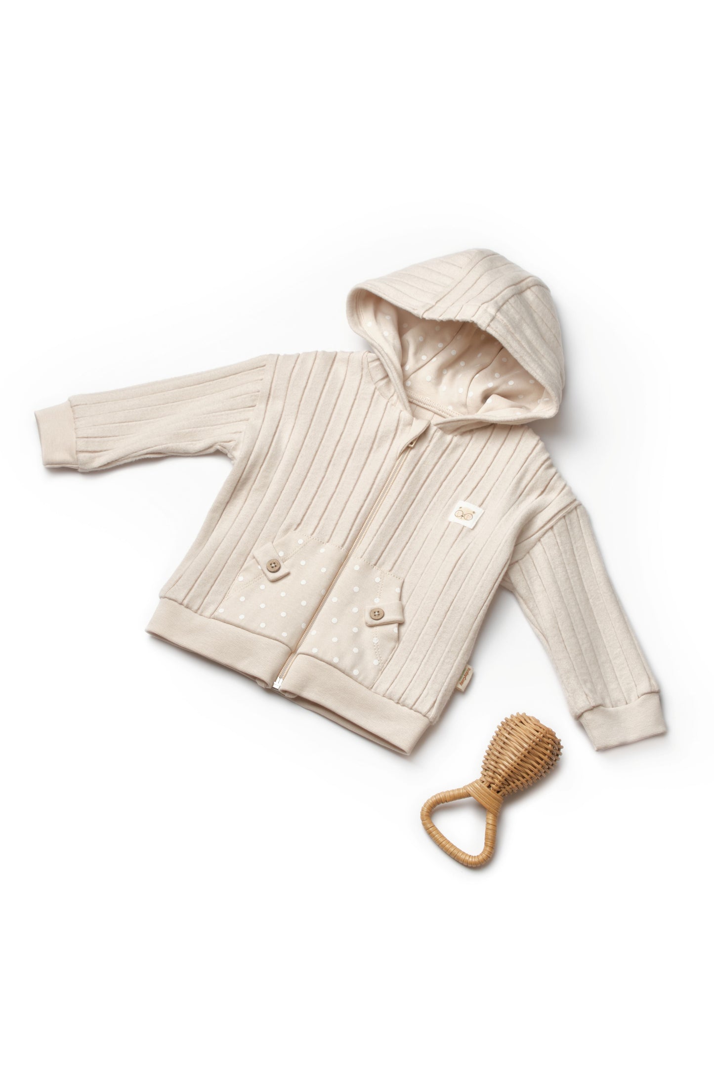 Beige baby jacket with hood and wooden teething ring on a white background