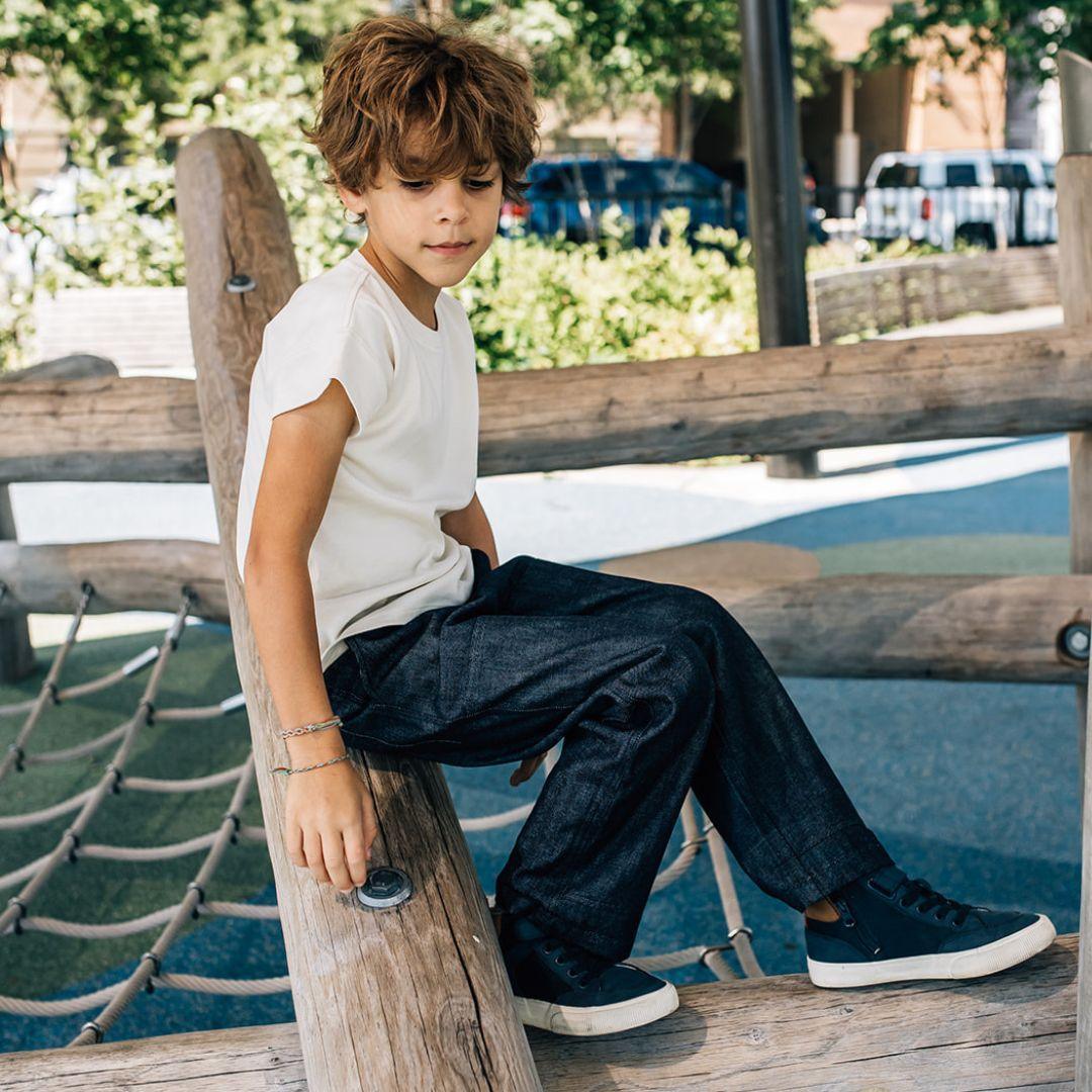 Child sitting on a wooden post at a playground