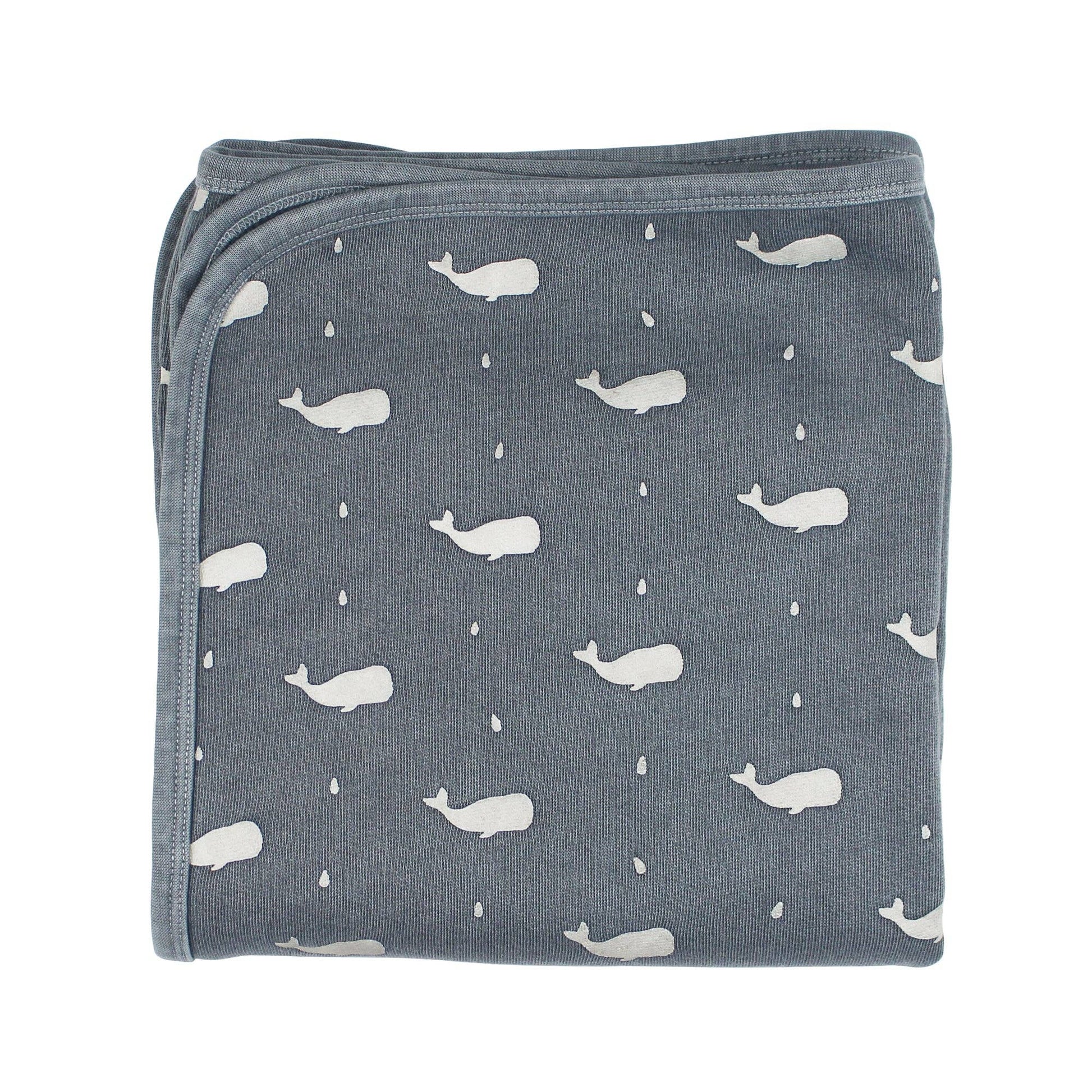 Folded blanket with whale pattern on a white background