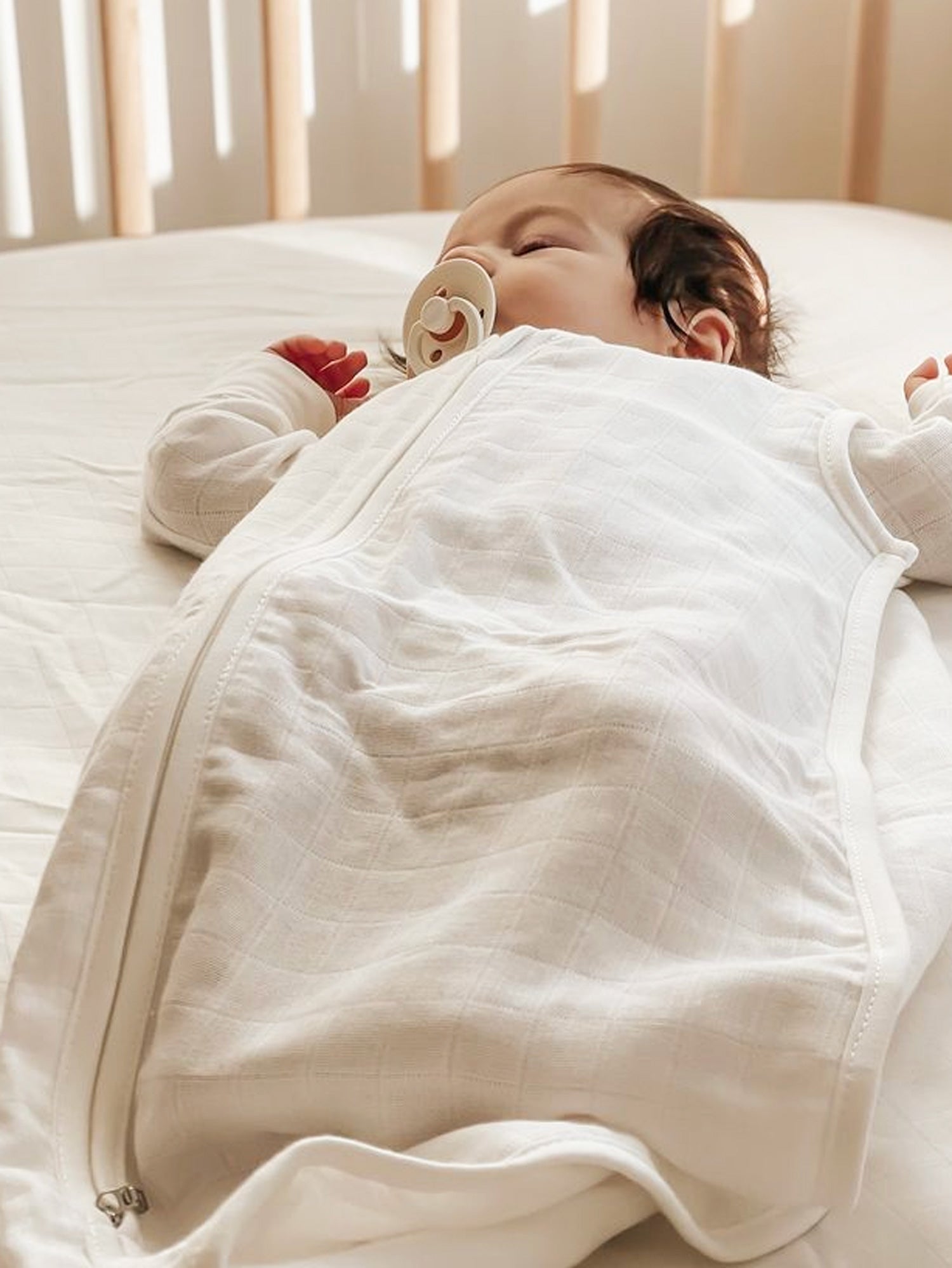 Baby lying in a crib in an Organic Muslin Sleep Sack