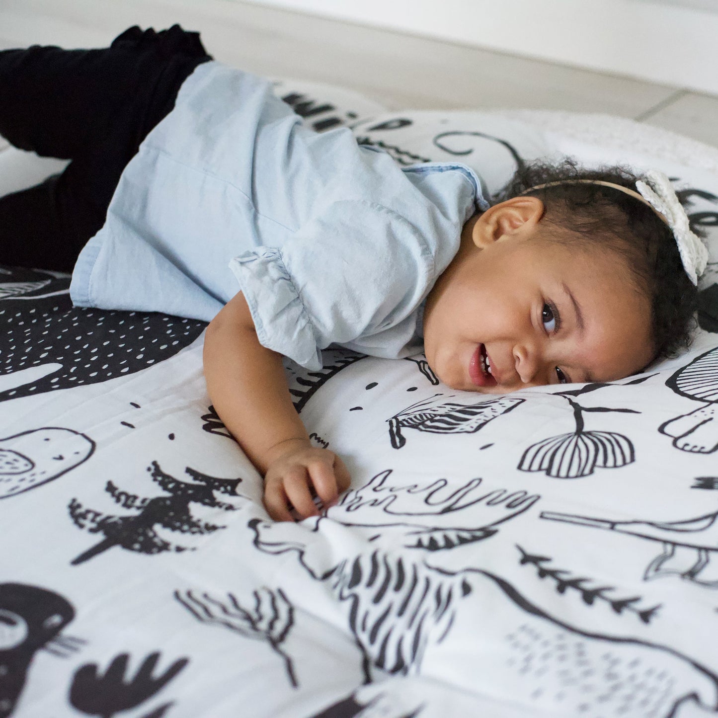 Baby lying on a patterned blanket with black and white designs
