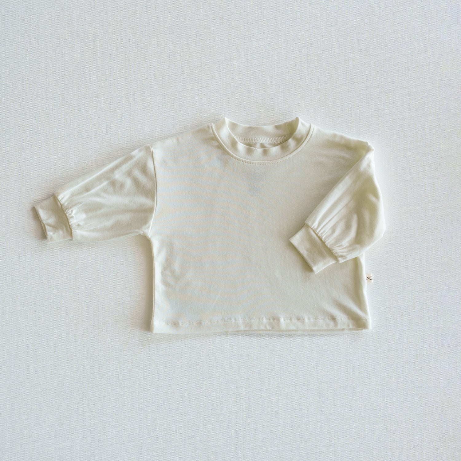 White long-sleeve shirt on a light gray background