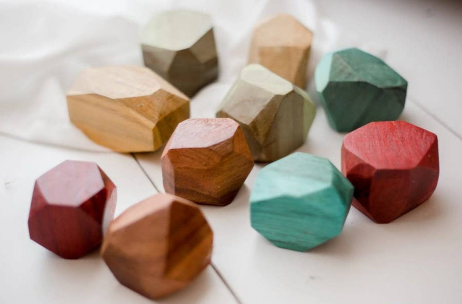 Colorful geometric wooden gems on a white surface
