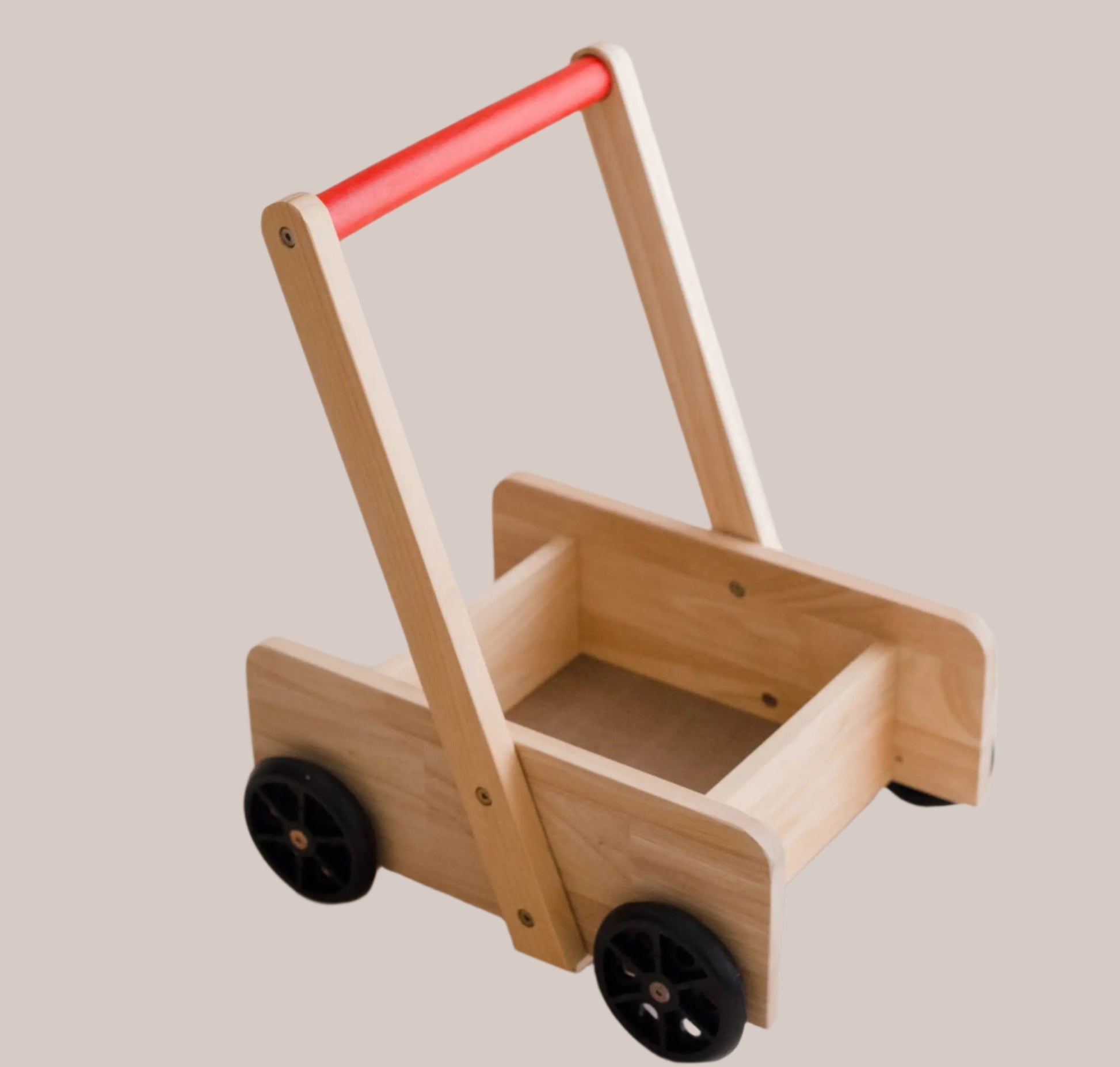 Wooden baby walker with a red handle on a light background