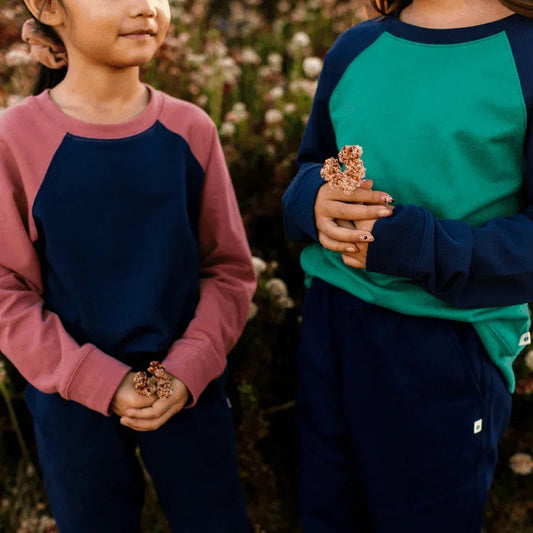 Two children holding small plants in a natural setting