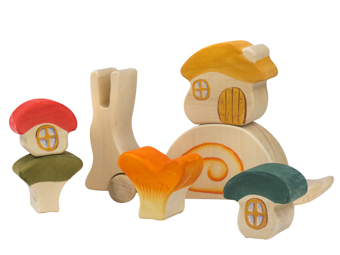 Set of wooden toy houses with mushroom-shaped roofs on a white background