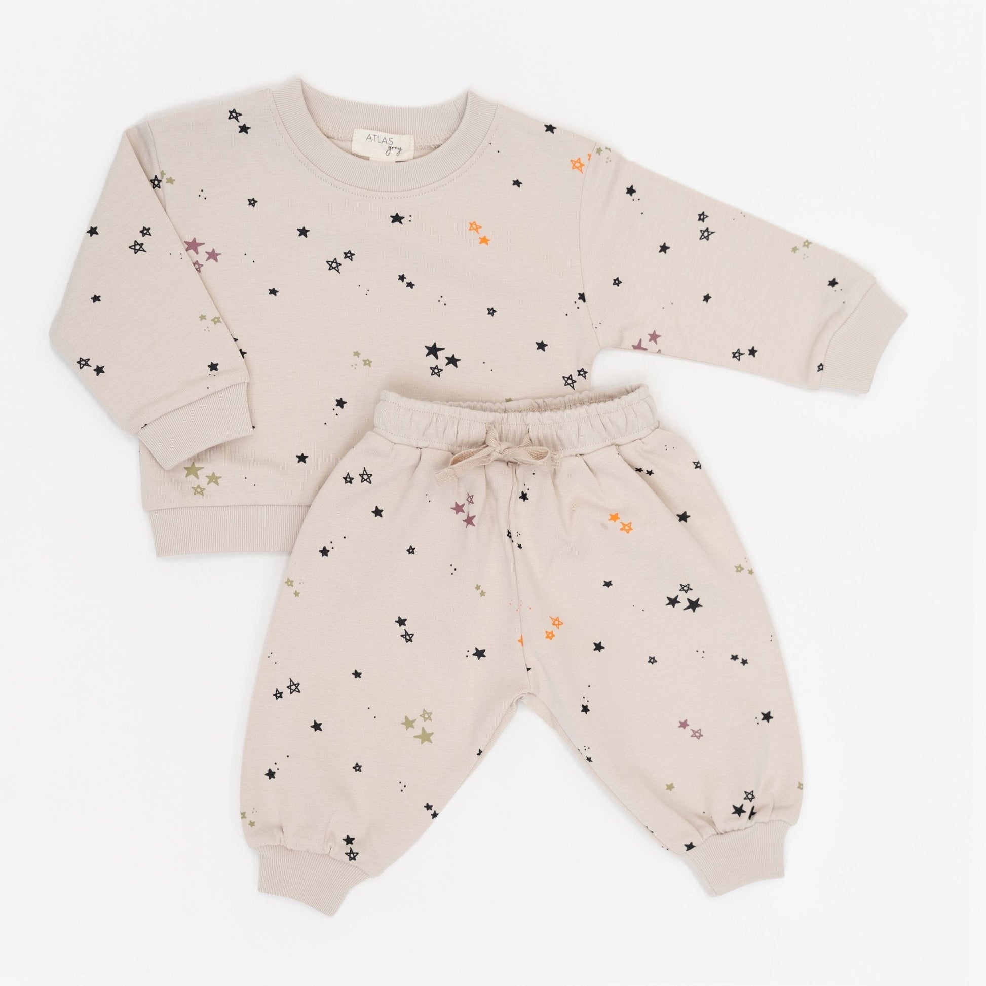 Beige baby outfit with star pattern on a white background