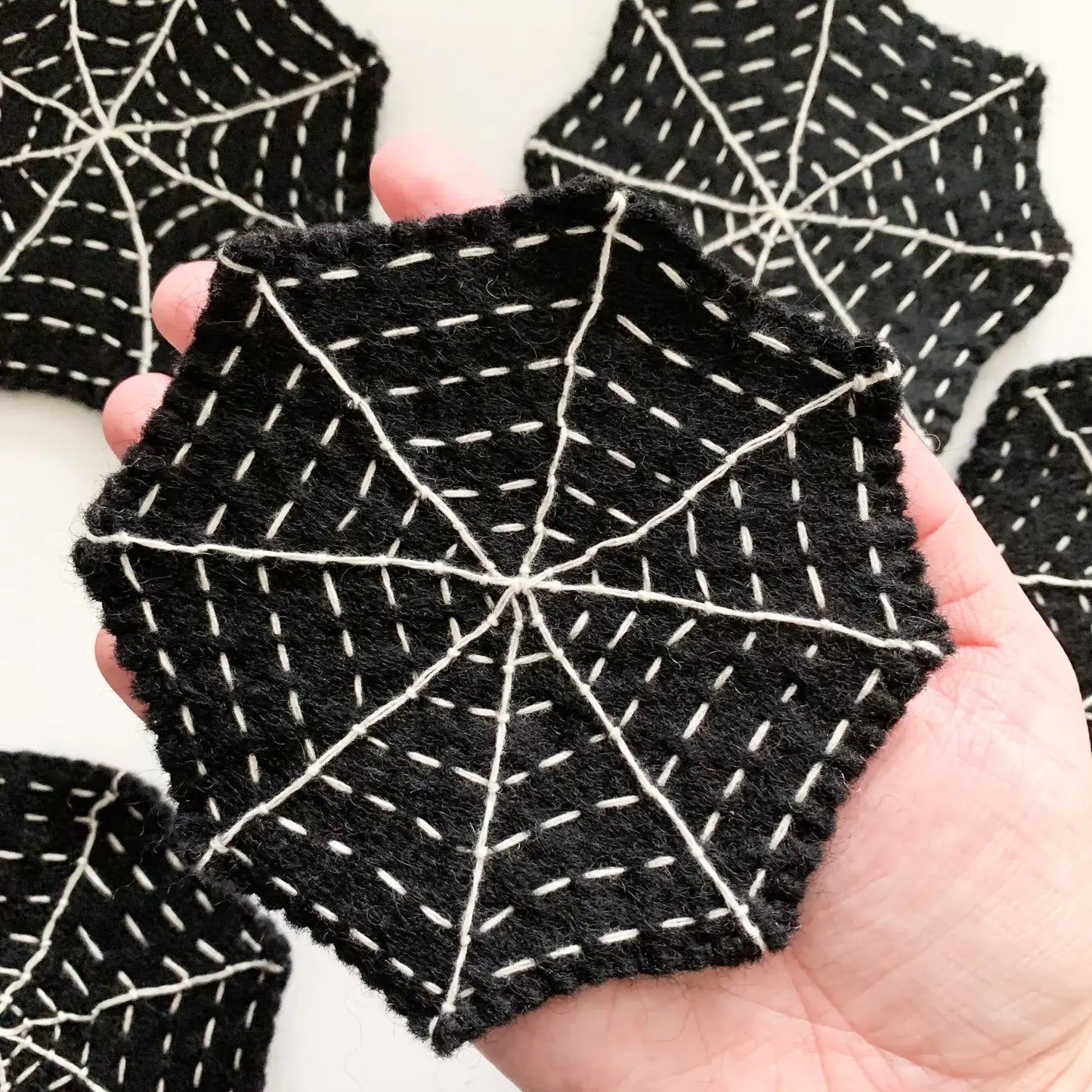 Hand holding a felt black spider web