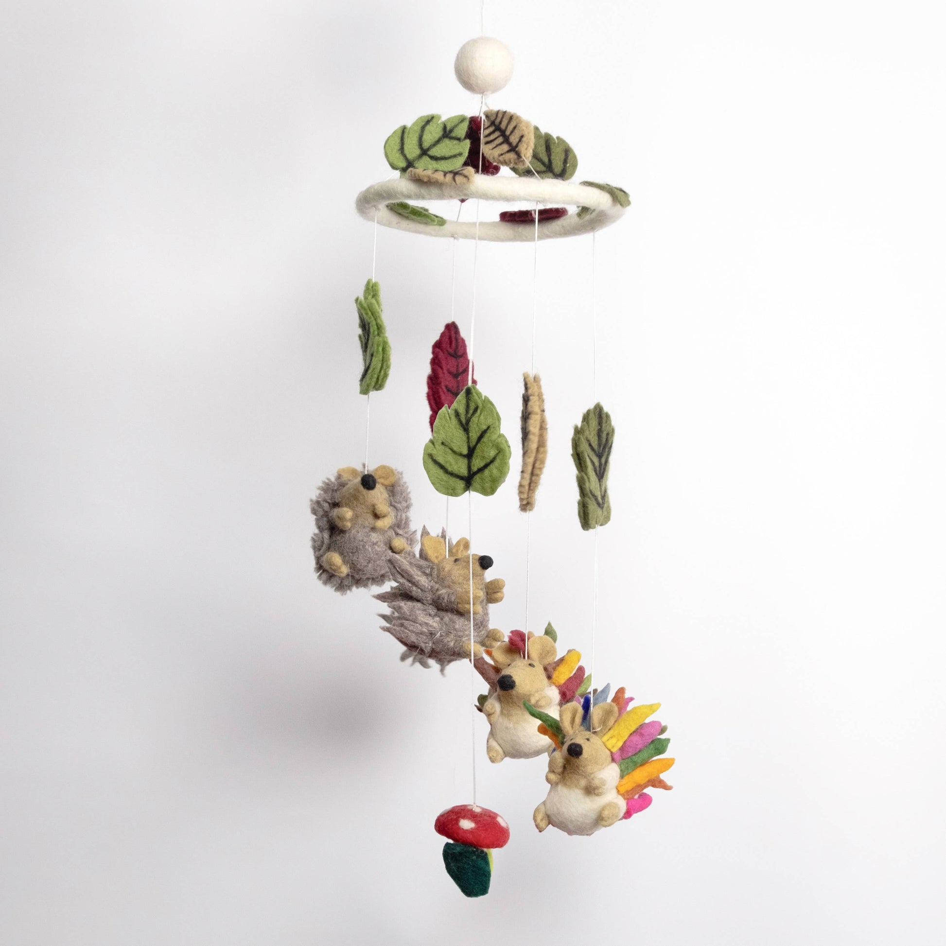 Children's mobile with hedgehogs, leaves, and mushrooms on a white background