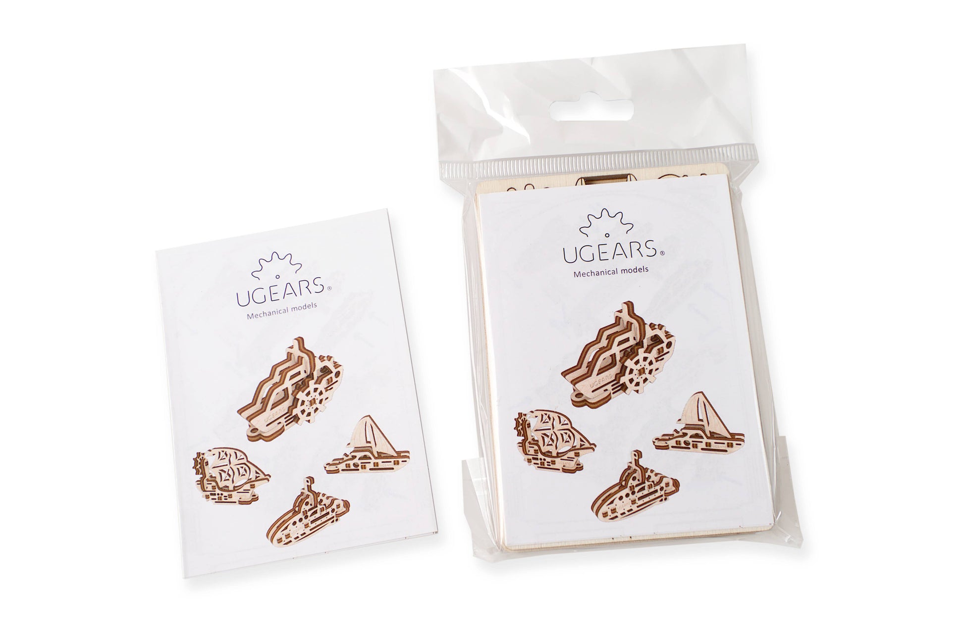 Two packages of Ugears wooden model ships on a white background