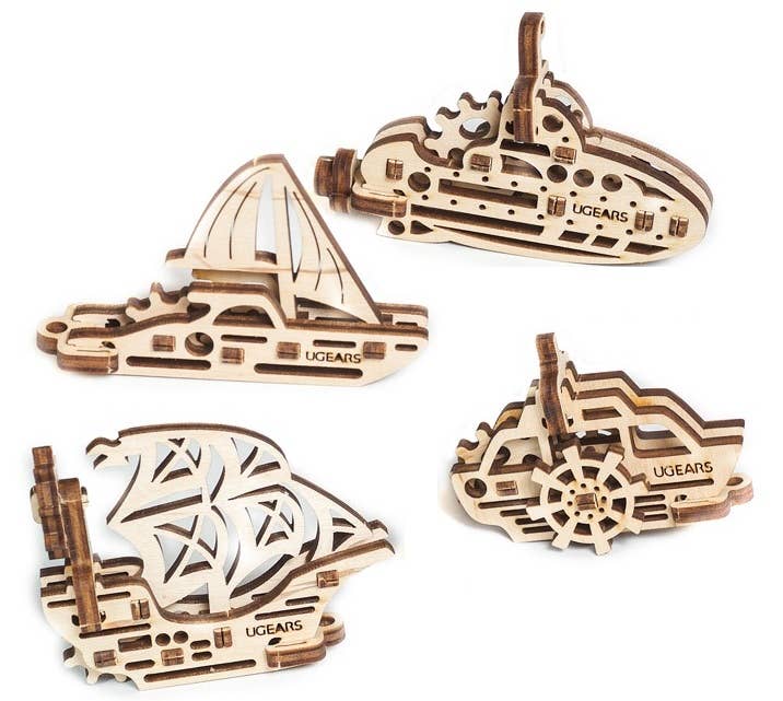 Four wooden mechanical ships model kits with 'Ugears' branding on a white background