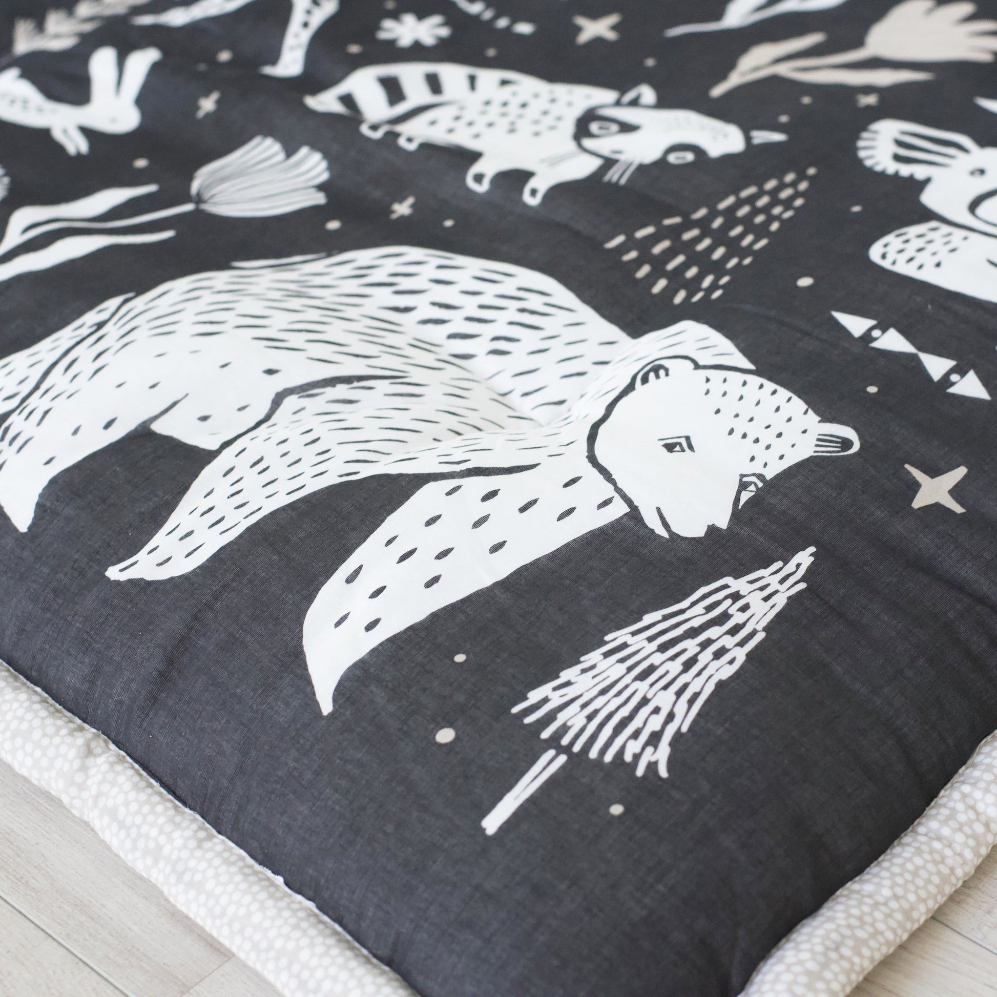 Dark fabric with white animal illustrations on a bed