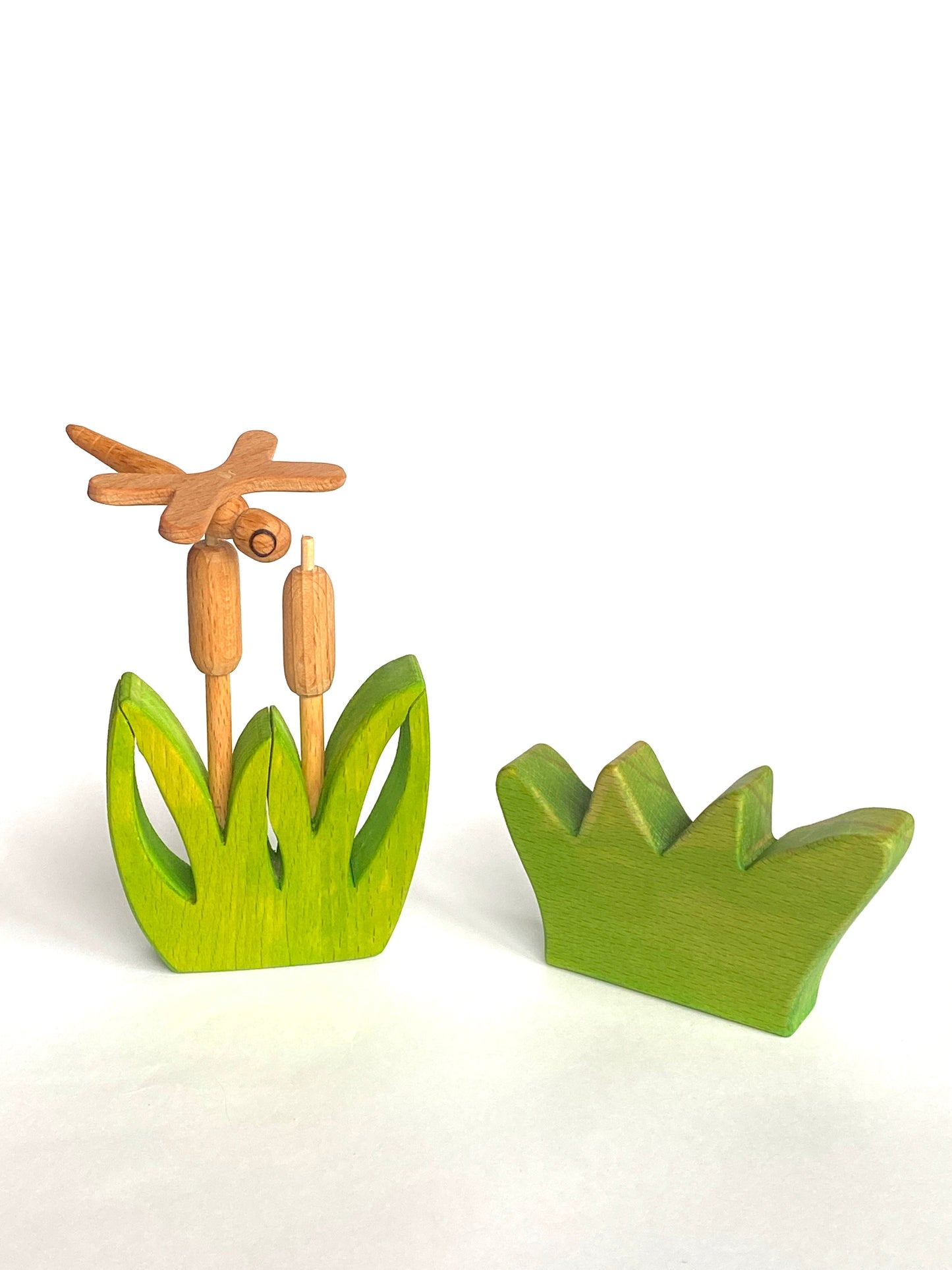 Wooden dragonfly and cattails on a white background