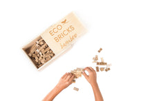 Load image into Gallery viewer, Kid building a structure with pieces from the Bamboo Eco-Bricks 250-piece set
