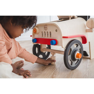 kid playing with the Motor Mechanic by Plan Toys