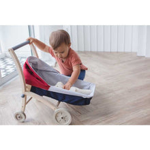 Load image into Gallery viewer, Toddler playing with a Doll Stroller by Plan Toys
