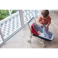 Load image into Gallery viewer, Toddler playing with a Doll Stroller by Plan Toys
