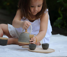 Load image into Gallery viewer, Child sitting outside playing with classic tea set by PlanToys
