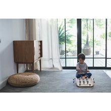 Load image into Gallery viewer, kid playing with a wood soccer game by Plan Toys
