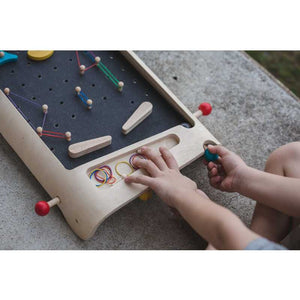 Child Playing Pinball Set by Plan Toys