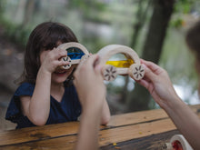 Load image into Gallery viewer, children sitting at a wooden table outdoors looking through wautomobiles

