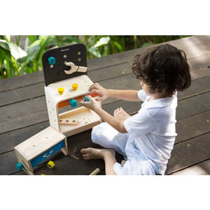 Child Playing with a Workbench by Plan Toys