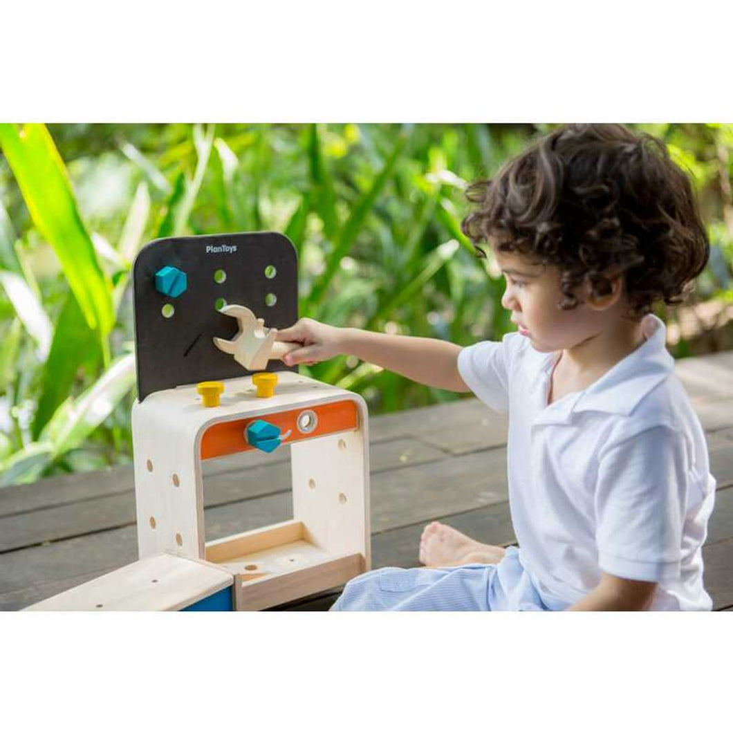 Child Playing with a Workbench by Plan Toys