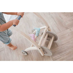 Toddler pushing a Woodpecker Walker BY PLAN TOYS
