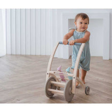 Load image into Gallery viewer, Toddler pushing a Woodpecker Walker BY PLAN TOYS
