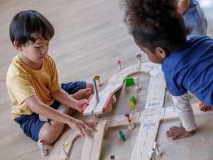 kids playing with Plan Toys Road System