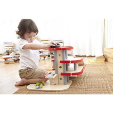 Load image into Gallery viewer, Child Playing with Parking Garage by Plan Toys
