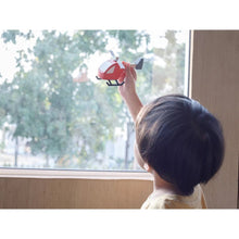 Load image into Gallery viewer, Child playing with helicopter by PlanToys in front of a window
