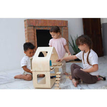 Load image into Gallery viewer, Three kids playing with the Contemporary Dollhouse by Plan Toys
