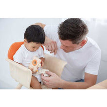 Load image into Gallery viewer, parent unbuckling the plan toys High Chair - Orange
