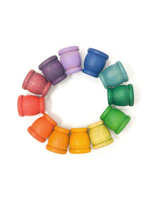 Rainbow wooden cups arranged in a circle in the color order of the rainbow.