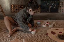 Load image into Gallery viewer, Child sorting the flower petal mandala in wooden cups
