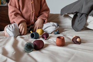 Child playing with Little Things on a bed